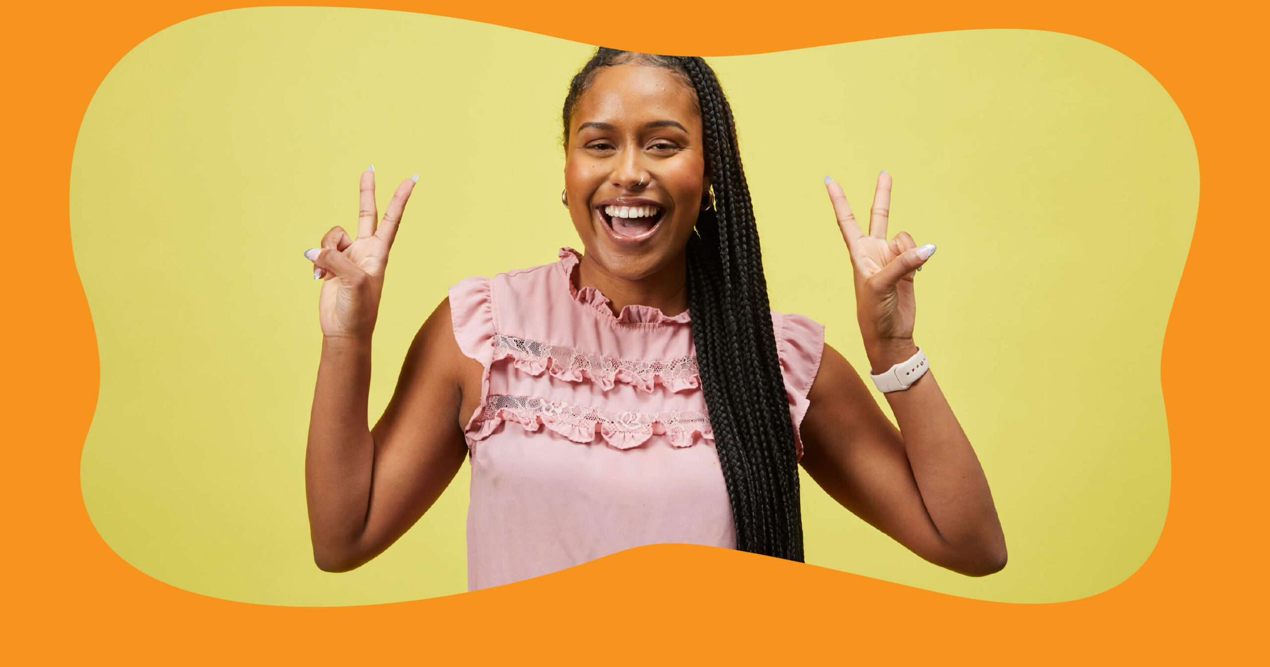 A Black female SA employee with long, braided hair and a wide smile stands in front of a yellow background, holding up both hands in peace signs. She is wearing a ruffled pink top and a white watch. The image is framed by an orange, organic-shaped border.